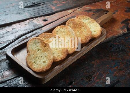 Tranches de baguette grillées sur une table de cuisine rustique en bois Banque D'Images