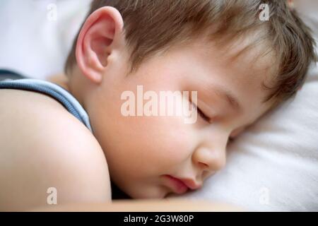 Le garçon dort sur un oreiller blanc. Portrait d'un enfant endormi. Banque D'Images