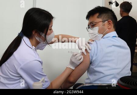 Tokyo, Tokyo, Japon. 18 juin 2021. Un homme reçoit une injection de vaccin COVID-19 au bureau du gouvernement métropolitain de Tokyo à Tokyo le 18 juin 2021, alors que le gouvernement métropolitain de Tokyo a commencé à vacciner les personnes impliquées dans les Jeux Olympiques de Tokyo en 2020. Crédit : POOL/ZUMA Wire/Alay Live News Banque D'Images