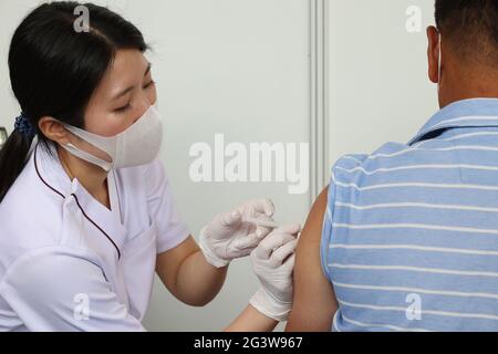 Tokyo, Tokyo, Japon. 18 juin 2021. Un homme reçoit une injection de vaccin COVID-19 au bureau du gouvernement métropolitain de Tokyo à Tokyo le 18 juin 2021, alors que le gouvernement métropolitain de Tokyo a commencé à vacciner les personnes impliquées dans les Jeux Olympiques de Tokyo en 2020. Crédit : POOL/ZUMA Wire/Alay Live News Banque D'Images