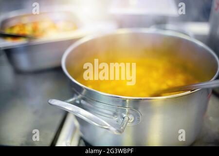 Préparation du premier plat dans la salle à manger. La soupe ou le chowder est cuit dans une casserole en aluminium sur une cuisinière électrique. Banque D'Images