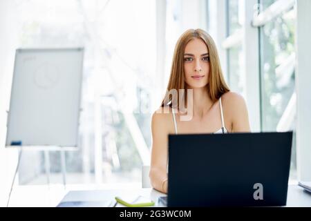 Femme d'affaires souriante et confiante dans un bureau moderne Banque D'Images