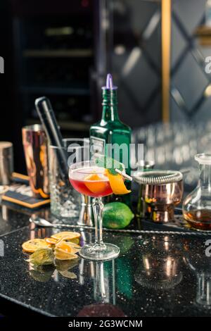 Plusieurs cocktails alcoolisés au bar dans différents verres. Décoration cocktail : citron vert, menthe, orange Banque D'Images