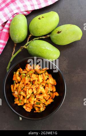 Salade de mangue verte. Pickle instantané à la mangue crue. Également connu sous le nom de kairi koshimbir à Marathi. Copier l'espace sur fond noir. Mangues vertes hachées. Banque D'Images