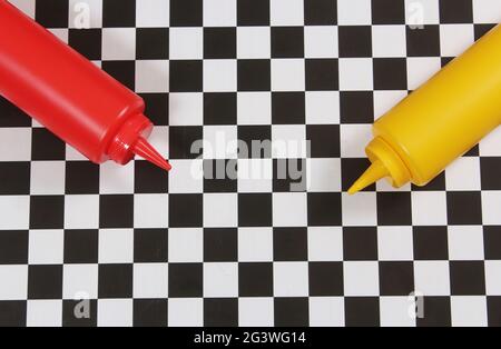 Bouteilles de ketchup et de moutarde sur une table à carreaux Banque D'Images