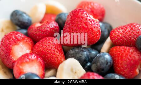 Bol de salade de fruits frais avec fraises, bleuets et tranches de banane Banque D'Images