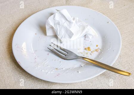 Vider la plaque avec la fourchette à gâteau et la serviette en papier émietté. Banque D'Images