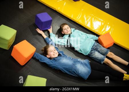 Loisirs actifs. Les enfants s'amusent sur le trampoline dans le centre de divertissement, l'enfance et le style de vie sportif. Garçon et fille à Leisu Banque D'Images