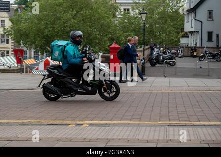 Deliveroo Rider sur un mobylette faisant une livraison de nourriture dans le centre-ville de Norwich au Royaume-Uni Banque D'Images