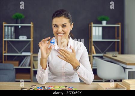 Jeune femme souriante montre le nombre 4. Une jeune femme dans un chemisier blanc d'apparence européenne Banque D'Images