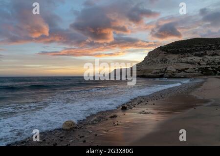Un magnifique coucher de soleil sur l'océan sur la Costa del sol in Espagne avec plage et falaises en arrière-plan Banque D'Images