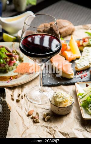 Verre de vin rouge sec, apéritif. Vin avec viande grillée et légumes. Gros plan. Concept - mise en table dans un restaurant. Banque D'Images