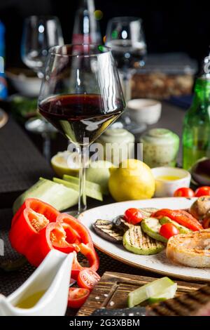 Verre de vin rouge sec, apéritif. Vin avec viande grillée et légumes. Gros plan. Concept - mise en table dans un restaurant. Banque D'Images