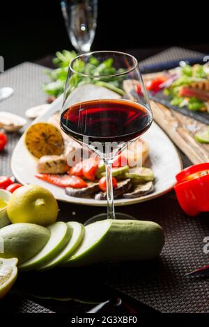 Verre de vin rouge sec, apéritif. Vin avec viande grillée et légumes. Gros plan. Concept - mise en table dans un restaurant. Banque D'Images