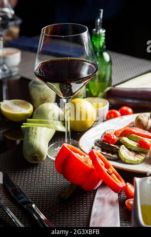 Verre de vin rouge sec, apéritif. Vin avec viande grillée et légumes. Gros plan. Concept - mise en table dans un restaurant. Banque D'Images