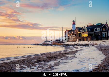 Hiver à Urk avec la digue et la plage près du phare d'Urk neige couverte pendant l'hiver, coucher de soleil par le phare d'Urk Flevo Banque D'Images