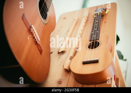 Ukulele: Gros plan d'un ukulele, prêt à jouer, accroché sur une étagère en bois Banque D'Images