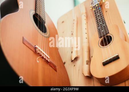 Ukulele: Gros plan d'un ukulele, prêt à jouer, accroché sur une étagère en bois Banque D'Images