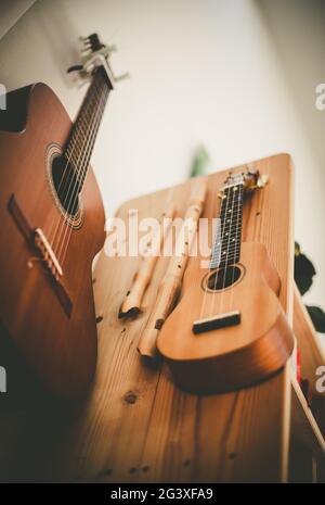 Ukulele: Gros plan d'un ukulele, prêt à jouer, accroché sur une étagère en bois Banque D'Images