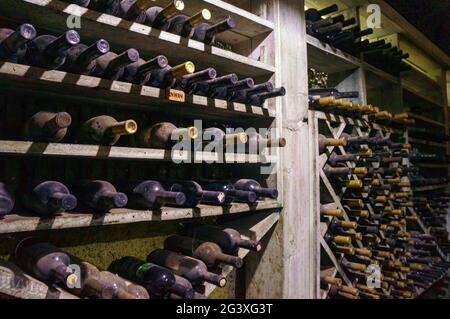 Cave à vin. Les bouteilles sur des étagères en bois. Stockage vintage de la collection de vins Banque D'Images