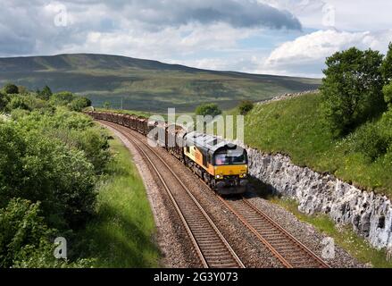 Un train transportant des grumes sur la ligne Settle-Carlisle dans le parc national de Yorkshire Dales. Le train se dirige vers les travaux de transformation du bois à Chirk. Banque D'Images