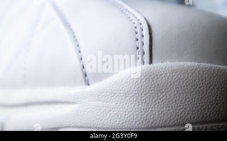 Gros plan sur la semelle extérieure des nouvelles sneakers blanches. Semelle en caoutchouc sur le pied des chaussures pour Homme. Semelle pour chaussures de sport et de marche Banque D'Images