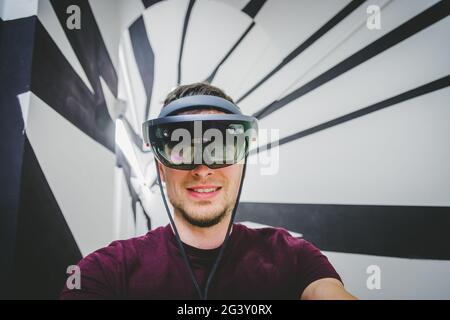 Jeune homme portant des lunettes de réalité virtuelle haut de gamme. Concept pour VR, futur, gadgets et technologie. Banque D'Images