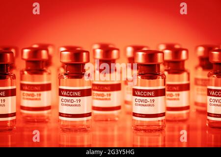 Flacons de vaccin Covid-19 sur fond rouge Banque D'Images