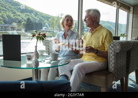 Couple prenant un café l'après-midi dans le salon Panorama à bord du bateau de croisière au cours d'une croisière sur le Rhin, Goarshausen Wellmich, Rhénanie-P Banque D'Images