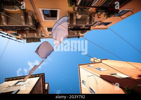 Vue d'en dessous sur les façades de maisons avec des vêtements à Cannaregio, Venise, Vénétie, Italie, Europe Banque D'Images