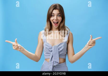 Stupéfait et surpris charismatique femme attrayante levant les mains pointant latéralement à gauche et à droite avec impressionné débordé expr Banque D'Images