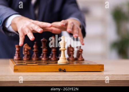 Un jeune homme jouant aux échecs sur le lieu de travail Banque D'Images