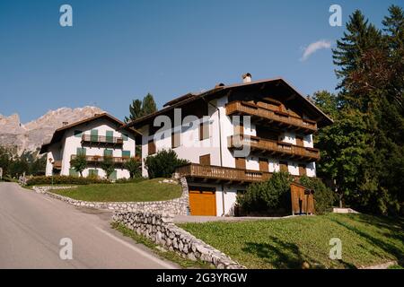 Maisons blanches et montagnes rocheuses avec forêt dense de verdure dans les Dolomites dans le Tyrol du Sud, Italie. Cortina Ampezzo est une ville italienne Banque D'Images