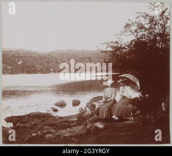 Deux femmes assises sur les rives du lac Tazenat à Charbonnières-les-vieilles. Partie d'un album photo d'un photographe amateur français avec des enregistrements de voyages en France, en Espagne, en Belgique, au Luxembourg et aux pays-Bas, les premières automobiles et les autoroutes. Banque D'Images