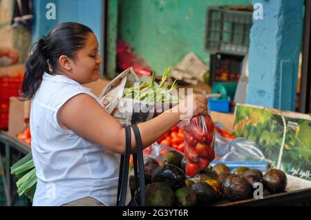 Une jeune femme achète des fruits et des légumes sur le marché de Merida au Mexique Banque D'Images