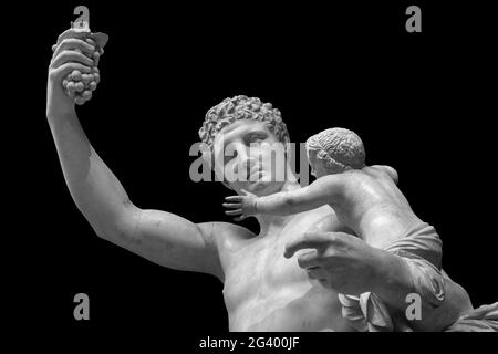 Statue de Dionysos ou de Bacchus avec bouquet de raisins isolés sur le noir Banque D'Images