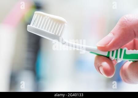 Brossage des dents : brosse à dents dans la salle de bains Banque D'Images