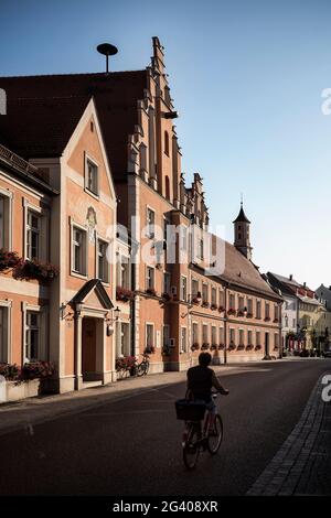 Une femme fait du vélo à l'hôtel de ville, Rain am Lech, Donau-Ries, Bavière, Danube, Allemagne Banque D'Images