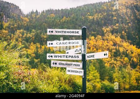 Panneaux de la rue touristique de l'Alaska montrant les directions de différentes villes touristiques les plus proches destination. Chilkoot, Whitehorse, Juneau, Skagway. Panneau de signalisation Banque D'Images