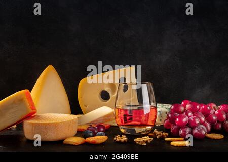 Fromage et vin, vue latérale sur fond noir Banque D'Images