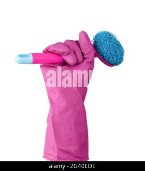 Main dans un gant en caoutchouc rose pour le nettoyage une maison contient une brosse en plastique avec une poignée Banque D'Images