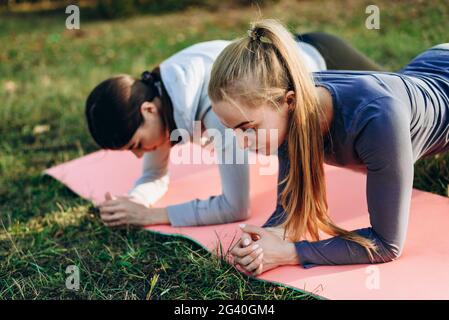 Photo de deux adorables filles faisant des exercices à l'extérieur. Bracelet sport Banque D'Images