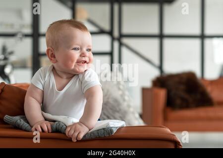 Belle, mignonne, petite fille debout sur le canapé se réjouit sincèrement Banque D'Images