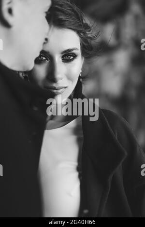 Portrait rapproché d'une mariée qui s'enserre avec le marié. De beaux yeux expressifs. Couple de mariage sur une photo noir et blanc. Déc Banque D'Images