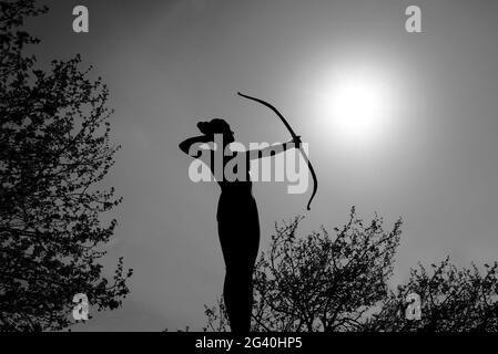 Statue de femme Silhouette Archer à l'arc cible le soleil Banque D'Images