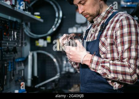 Atelier de vélo mécanique fixant la roue de vélo dans l'atelier. Réparation par un technicien de maintenance, cycle d'entretien. Velocipede réparation de vélo en vélo Banque D'Images