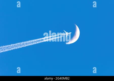 L'avion passager passe près de la lune Banque D'Images