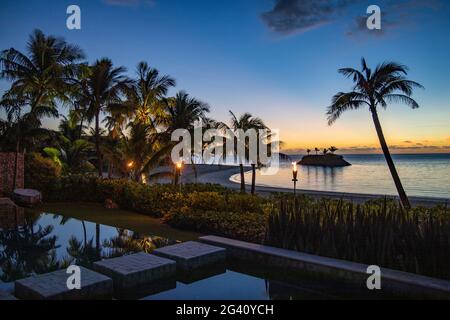 Tiki torches et piscine privée d'une résidence villa logement à six Senses Fiji Resort au crépuscule, Malolo Island, Mamanuca Group, Fidji Islan Banque D'Images