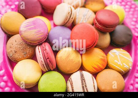 De nombreux macarons se ferment sur la table. Nombreuses pâtisseries françaises colorées au macaron Banque D'Images