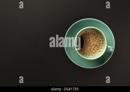 Une tasse de café sur fond noir, prise par le dessus avec Banque D'Images